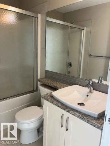 Bathroom with vanity, light tile patterned floors, and shower / bath combination with glass door - 2433 Glenridding Boulevard, Edmonton, AB - Indoor Photo Showing Bathroom