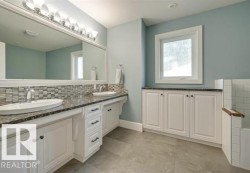 Full bathroom featuring double vanity, a bathtub, and decorative backsplash - 