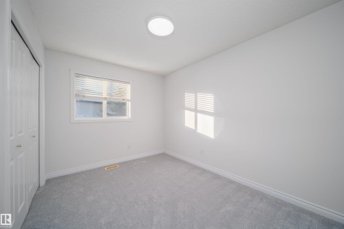 Unfurnished bedroom featuring a closet, multiple windows, and carpet - 3504 20 Street, Edmonton, AB - Indoor Photo Showing Other Room