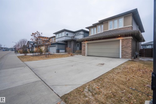 Prairie-style house featuring concrete driveway, stone siding, and a garage - 2060 Ware Road, Edmonton, AB - Outdoor