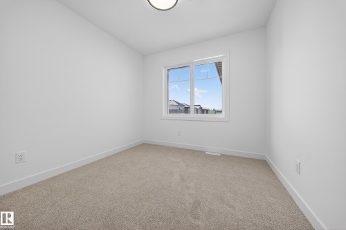 Carpeted empty room featuring baseboards and lofted ceiling - 129 Pierwyck Loop, Spruce Grove, AB - Indoor Photo Showing Other Room