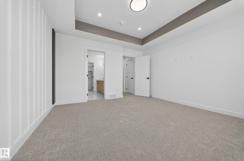 Unfurnished bedroom with light carpet, a raised ceiling, ensuite bathroom, and recessed lighting - 129 Pierwyck Loop, Spruce Grove, AB - Indoor Photo Showing Other Room