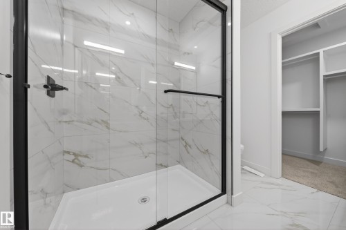Bathroom with light marble finish flooring, a marble finish shower, and a walk in closet - 129 Pierwyck Loop, Spruce Grove, AB - Indoor Photo Showing Bathroom
