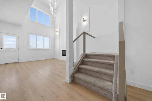 Staircase with a high ceiling, wood finished floors, and healthy amount of natural light - 129 Pierwyck Loop, Spruce Grove, AB - Indoor Photo Showing Other Room