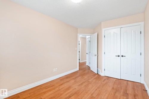 Unfurnished bedroom featuring light wood finished floors, a closet, and a textured ceiling - 1888 33 Street, Edmonton, AB - Indoor Photo Showing Other Room