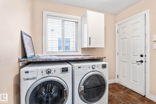 Laundry area featuring washing machine and clothes dryer and cabinet space - 1888 33 Street, Edmonton, AB - Indoor Photo Showing Laundry Room