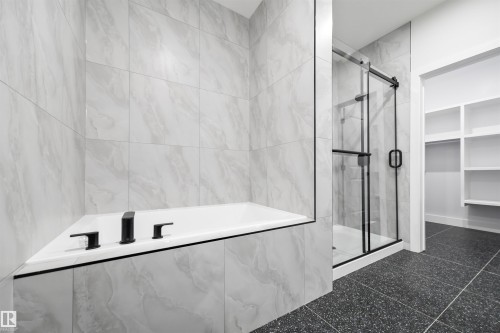 Bathroom featuring a garden tub, a marble finish shower, and a walk in closet - 3164 Magpie Way, Edmonton, AB - Indoor Photo Showing Bathroom