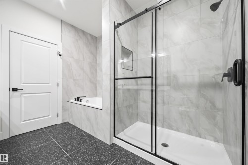 Full bath featuring a garden tub, a stall shower, and tile walls - 3164 Magpie Way, Edmonton, AB - Indoor Photo Showing Bathroom