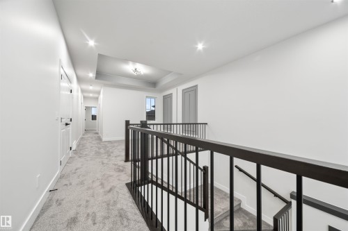 Hallway featuring an upstairs landing, light carpet, and a tray ceiling - 3164 Magpie Way, Edmonton, AB - Indoor Photo Showing Other Room