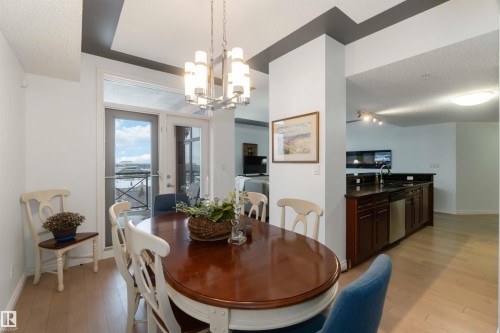 Dining room featuring a textured ceiling, a chandelier, and light wood-style floors - 1101 9020 Jasper Avenue, Edmonton, AB - Indoor Photo Showing Dining Room