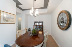 Dining space featuring a chandelier, light wood finished floors, and a tray ceiling - 