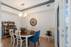 Dining space with light wood-type flooring, a chandelier, and a raised ceiling - 