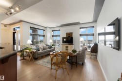 Living room with a textured ceiling, light wood-type flooring, and track lighting - 