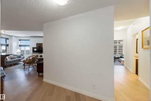 Corridor with light wood finished floors and a textured ceiling - 1101 9020 Jasper Avenue, Edmonton, AB - Indoor