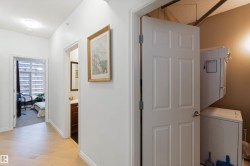 Hall with stacked washer / dryer, a textured ceiling, and light wood-style floors - 