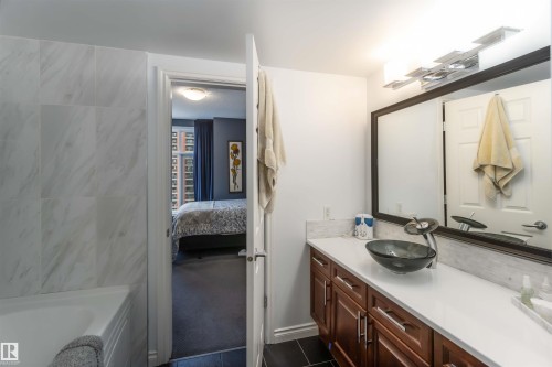 Ensuite bathroom with vanity, a tub to relax in, and dark tile patterned flooring - 1101 9020 Jasper Avenue, Edmonton, AB - Indoor Photo Showing Bathroom