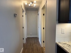 Hallway with attic access and dark wood finished floors - 