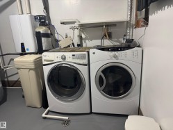 Washroom with washing machine and clothes dryer and tankless water heater - 