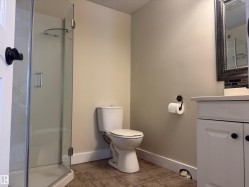 Bathroom with a stall shower, vanity, and light tile patterned floors - 