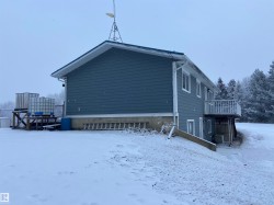 View of snow covered exterior featuring a wooden deck - 