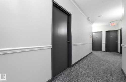 Hall with dark carpet and crown molding - 205 11440 40 Ave, Edmonton, AB - Indoor Photo Showing Other Room