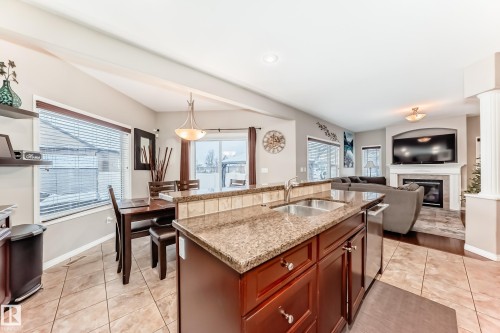 25 Woodbridge Link, Fort Saskatchewan, AB - Indoor Photo Showing Kitchen With Fireplace With Double Sink
