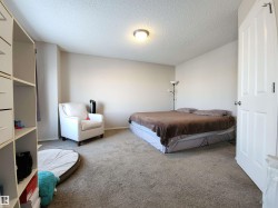Carpeted bedroom with a textured ceiling and baseboards - 