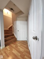 Staircase with wood finished floors and baseboards - 