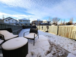 Snow covered patio with a residential view and a fenced backyard - 