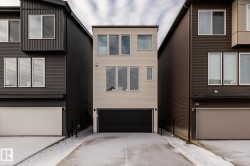 View of front of home with concrete driveway and an attached garage - 
