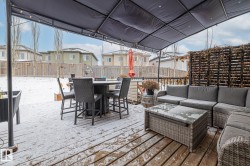 Snow covered deck featuring a residential view, a fenced backyard, outdoor lounge area, and outdoor dining area - 