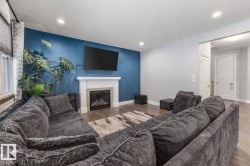 Living room with wood finished floors and a glass covered fireplace - 