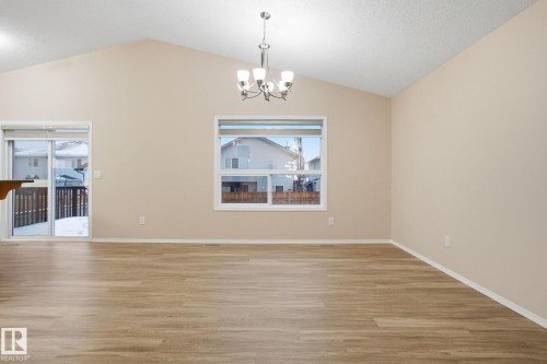 Unfurnished dining area featuring light wood-style flooring, a chandelier, and vaulted ceiling - 3316 24 Avenue, Edmonton, AB - Indoor Photo Showing Other Room