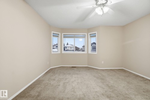 Empty room featuring light carpet and ceiling fan - 3316 24 Avenue, Edmonton, AB - Indoor Photo Showing Other Room