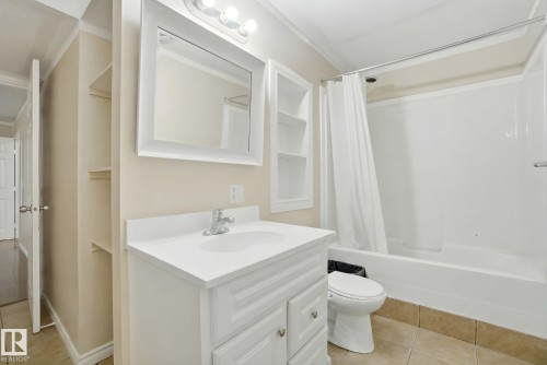 Full bathroom with light tile patterned floors, vanity, shower / bath combination with curtain, and ornamental molding - 3316 24 Avenue, Edmonton, AB - Indoor Photo Showing Bathroom
