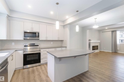54 2072 Wonnacott Way, Edmonton, AB - Indoor Photo Showing Kitchen With Fireplace