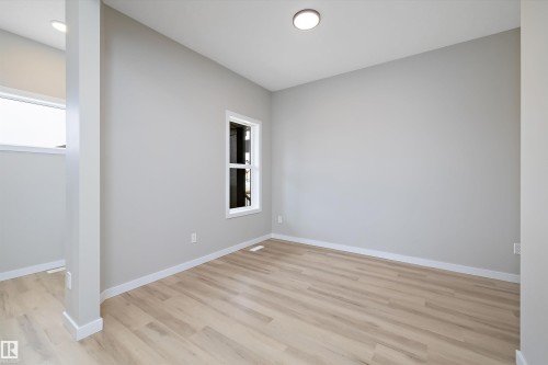 Empty room with baseboards and light wood-style flooring - 4544 Kinsella Link, Edmonton, AB - Indoor Photo Showing Other Room