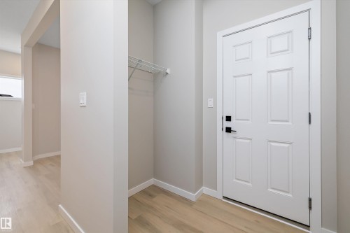 Laundry area with baseboards and light wood-type flooring - 4544 Kinsella Link, Edmonton, AB - Indoor