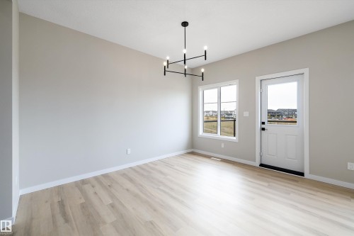 Unfurnished dining area featuring light wood-style floors and a chandelier - 4544 Kinsella Link, Edmonton, AB - Indoor Photo Showing Other Room