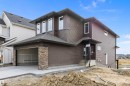 View of front of property with a garage, a shingled roof, stone siding, and concrete driveway - 4544 Kinsella Link, Edmonton, AB  - Outdoor 
