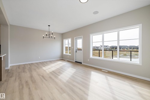 Unfurnished dining area featuring a chandelier and light wood-type flooring - 4544 Kinsella Link, Edmonton, AB - Indoor Photo Showing Other Room