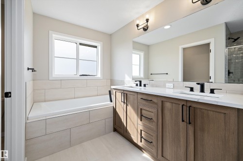 Bathroom with double vanity, a bath, a stall shower, and light tile patterned flooring - 4544 Kinsella Link, Edmonton, AB - Indoor Photo Showing Bathroom