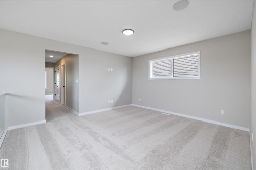 Unfurnished room with light colored carpet - 4544 Kinsella Link, Edmonton, AB - Indoor Photo Showing Other Room