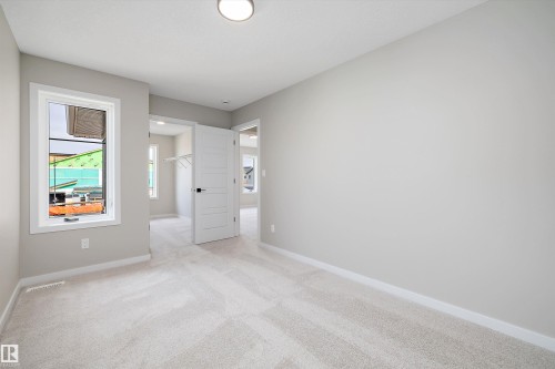 Unfurnished bedroom with light colored carpet and a spacious closet - 4544 Kinsella Link, Edmonton, AB - Indoor Photo Showing Other Room