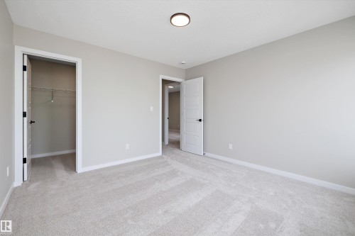 Unfurnished bedroom with light carpet and a walk in closet - 4544 Kinsella Link, Edmonton, AB - Indoor Photo Showing Other Room