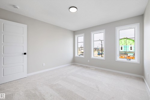 Unfurnished room featuring light carpet and baseboards - 4544 Kinsella Link, Edmonton, AB - Indoor Photo Showing Other Room