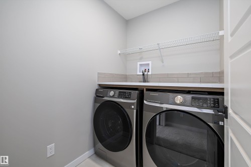 Laundry room featuring baseboards and independent washer and dryer - 4544 Kinsella Link, Edmonton, AB - Indoor Photo Showing Laundry Room