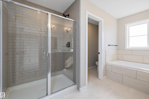 Full bathroom with a stall shower, a garden tub, and light tile patterned flooring - 4544 Kinsella Link, Edmonton, AB - Indoor Photo Showing Bathroom