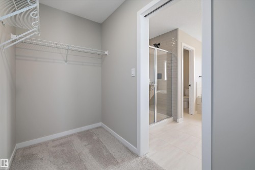 Spacious closet featuring light carpet and light tile patterned flooring - 4544 Kinsella Link, Edmonton, AB - Indoor