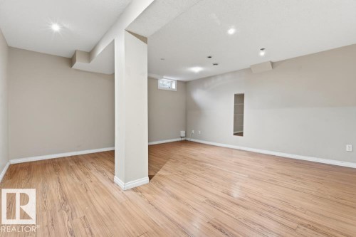 Below grade area featuring baseboards and light wood-style floors - 196 Roseland Village, Edmonton, AB - Indoor Photo Showing Other Room